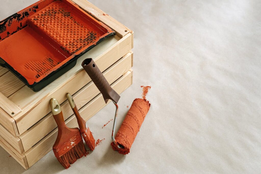 A collection of painting tools and supplies for home improvement projects, featuring brushes and a roller.